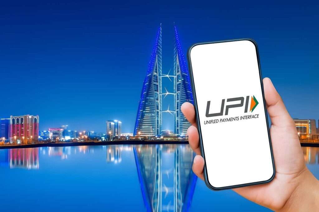 Smartphone showing UPI logo in front of Bahrain World Trade Center at night